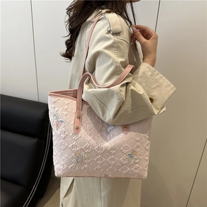 Pink quilted tote bag featuring elegant embroidered butterflies and faux leather straps