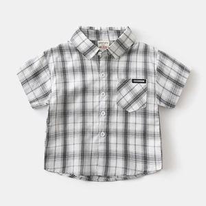 Close-up of boys classic plaid shirt featuring a pocket with Fashion label