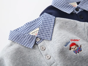 Detailed view of kids' polo shirts featuring cartoon puppy embroidery and plaid collar
