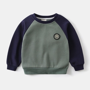 Detail of waffle knit fabric and raglan sleeve design on children's crewneck sweatshirt