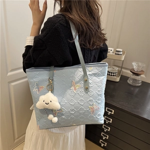 Light blue butterfly tote bag with sequin embroidery and cloud charm on model's shoulder