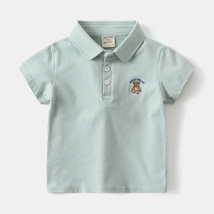 Detail of mint green cotton polo shirt featuring white buttons and bear chest embroidery