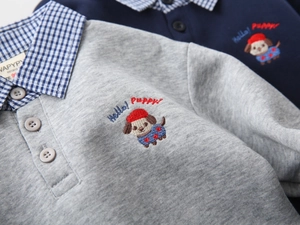 Detail of kids polo sweatshirt featuring cute puppy embroidery and fine fabric texture
