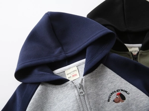 Detail of child hoodie showing cartoon dog embroidery and branded collar label