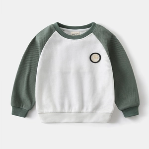 Close-up of boys' waffle knit raglan sweatshirt showing textured fabric and chest embroidery
