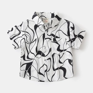 Détail d'une chemise à manches courtes pour garçon avec motifs noirs et poche poitrine