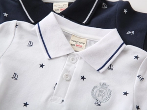Detail of cotton polo shirt fabric showing breathable texture and embroidered crown badge