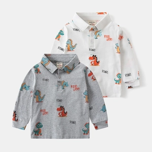 Detail of baby polo shirts with cartoon dinosaur prints and ribbed cuffs on soft cotton fabric