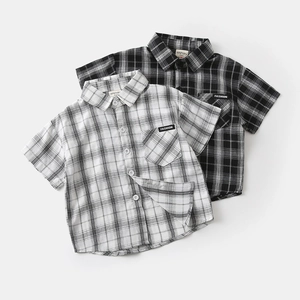Detailed view of kids' plaid short sleeve shirts with collar and front pocket patch