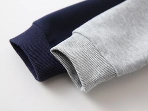 Detail of ribbed cuffs on navy and heather gray hoodies made from premium cotton blend
