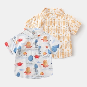 Detail view of cotton boy shirts featuring colorful ocean animal prints and fishbone patterns