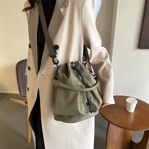 Chic olive green nylon bucket bag with drawstring closure and adjustable shoulder strap