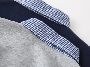 Detail of boys' polo sweatshirt collars featuring blue gingham fabric and knit texture
