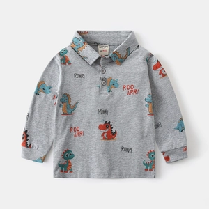 Detailed view of kids grey polo shirt with colorful dinosaur prints and soft cotton texture
