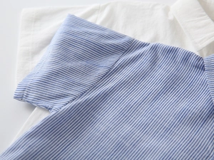 Nahaufnahme von Jungenhemd mit blau-weißen Streifen, Baumwollleinen und Kragendetails