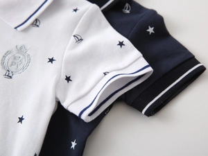 Detailed macro view of pique cotton boys' polo shirts with nautical anchor and star prints