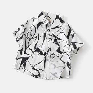 Détail d'une chemise d'été pour garçon avec motifs tourbillons et ourlet fendu