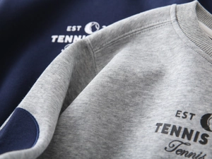 Macro shot of high-quality knit cotton fabric texture and tennis themed chest print