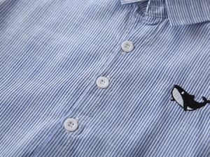 Detail von blau-weiß gestreiftem Jungenhemd mit Stickerei und weißen Knöpfen