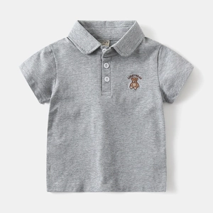 Close-up of grey polo shirt featuring a bear embroidery and luckybear text on the chest