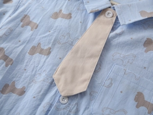 Detail of light blue boys short-sleeved shirt with cartoon horse print and beige tie