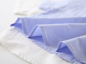 Close-up of sky blue cotton shirt fabric showing high-quality stitching and texture