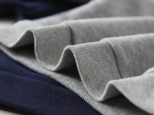 Macro detail of navy smooth jersey and grey ribbed knit cotton fabric on kid sweatshirt