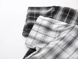 Close-up of boys plaid cotton shirt fabric showing uniform stitching and checkered pattern