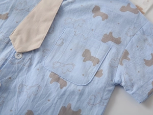 Detail of light blue boys' cotton shirt with brown pony print and matching khaki tie