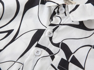 Détail d'une chemise pour garçons avec motifs abstraits noirs et col à boutons