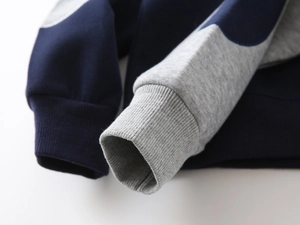 Detail of ribbed cuffs on a navy and grey contrast color sweatshirt for boys