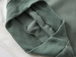 Detail of sage green waffle fabric with elastic ribbed cuffs on toddler sweatshirt