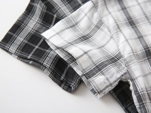 Close-up of boys' plaid short sleeve shirt showing stitching detail and woven fabric texture