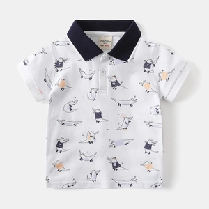 Detail of kid's white polo shirt featuring navy collar and cartoon crocodile print
