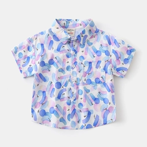 Detail view of the colorful abstract print, chest pocket, and sharp collar of the kids shirt