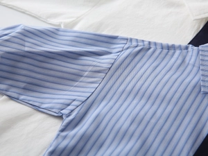 Dettaglio della cucitura della spalla e del tessuto a righe blu della camicia da bambino