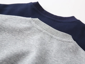 Detail of ribbed crew neck design on navy blue and heather grey boys' sweatshirts