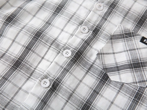 Close-up of black and white checkered fabric with chest pocket and FA logo on kids shirt