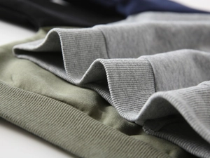 Detailed macro shot of ribbed cuffs and elastic hem on colorful kids knit hoodies