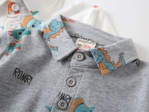 Detail shot of boys' polo shirt collar with dinosaur print and knit fabric texture