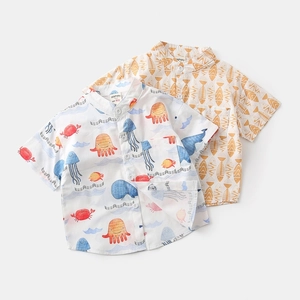 Flat lay detail of boys' short-sleeved shirts with marine life and fishbone prints