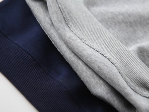 Detailed macro view of ribbed knit cuffs and double-stitched seams on kids' hoodies