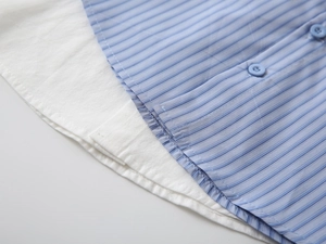 Dettaglio camicia a righe bambino con colletto a strati e bottoni blu rifiniti