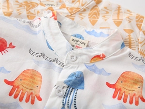 Detailed view of kids' cotton shirts featuring ocean prints and V-neck button closure
