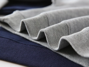 Detailed macro view of high-quality ribbed cotton cuffs on a navy blue boys sweatshirt