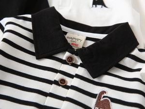 Close-up of children's striped polo shirt collar featuring dinosaur embroidery detail
