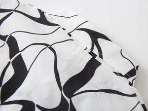 Détail du col d'une chemise blanche pour garçon avec motif abstrait et coutures fines