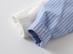 Dettaglio dei polsini della camicia da bambino con cuciture rifinite e trama del cotone