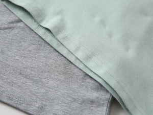 Detailed view of mint green and grey knit fabric with durable double-needle stitching