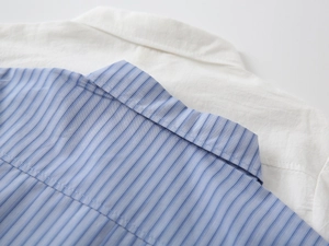 Dettaglio del colletto di camicie a maniche lunghe da ragazzo in cotone a righe e bianco